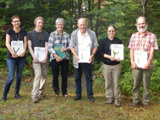 Les organisateurs et les animateurs saluent Jean Faubert en exhibant fièrement leur Flore des bryophytes du Québec - Labrador. - Photo : Kellina Higgins